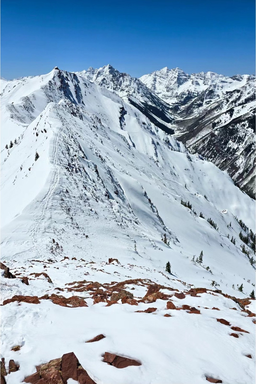 Skier looking out over steep alpine terrain