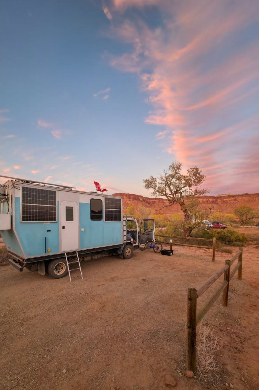 The house truck parked at sunset in the desert with a red camp chair